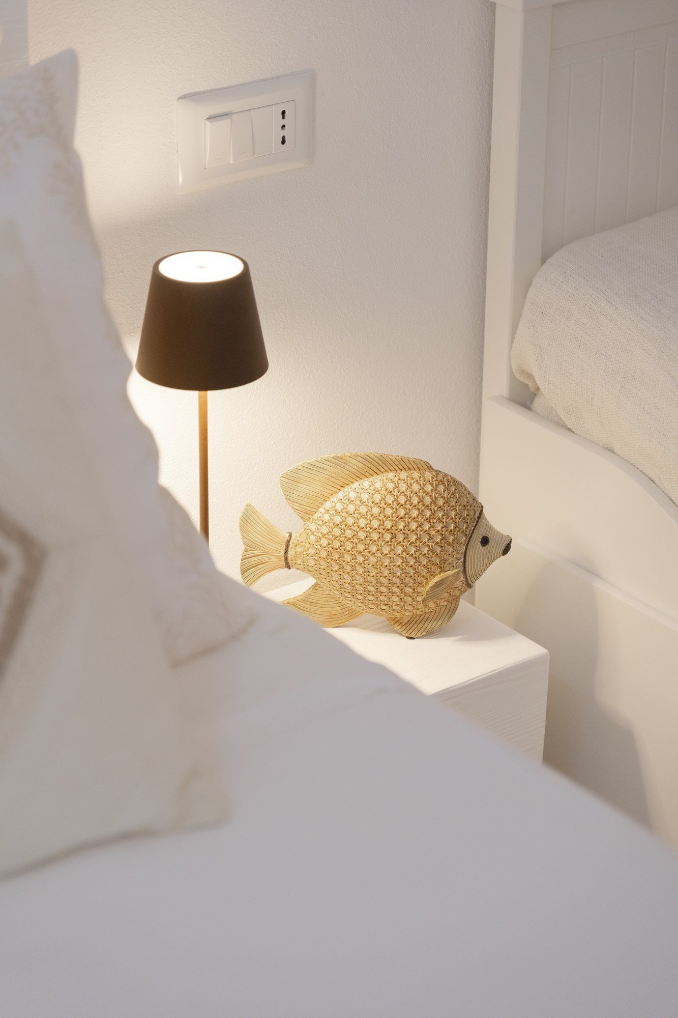 Dettaglio comodino con pesce in rattan e lampada