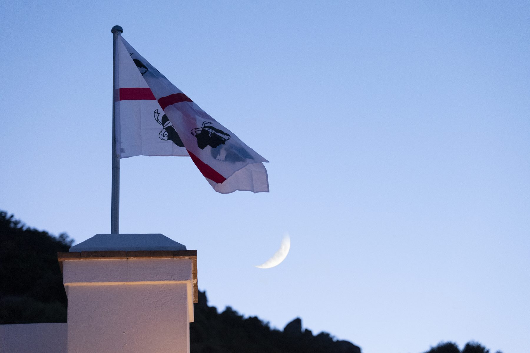 Bandiera dei Quattro Mori al crepuscolo con la luna crescente