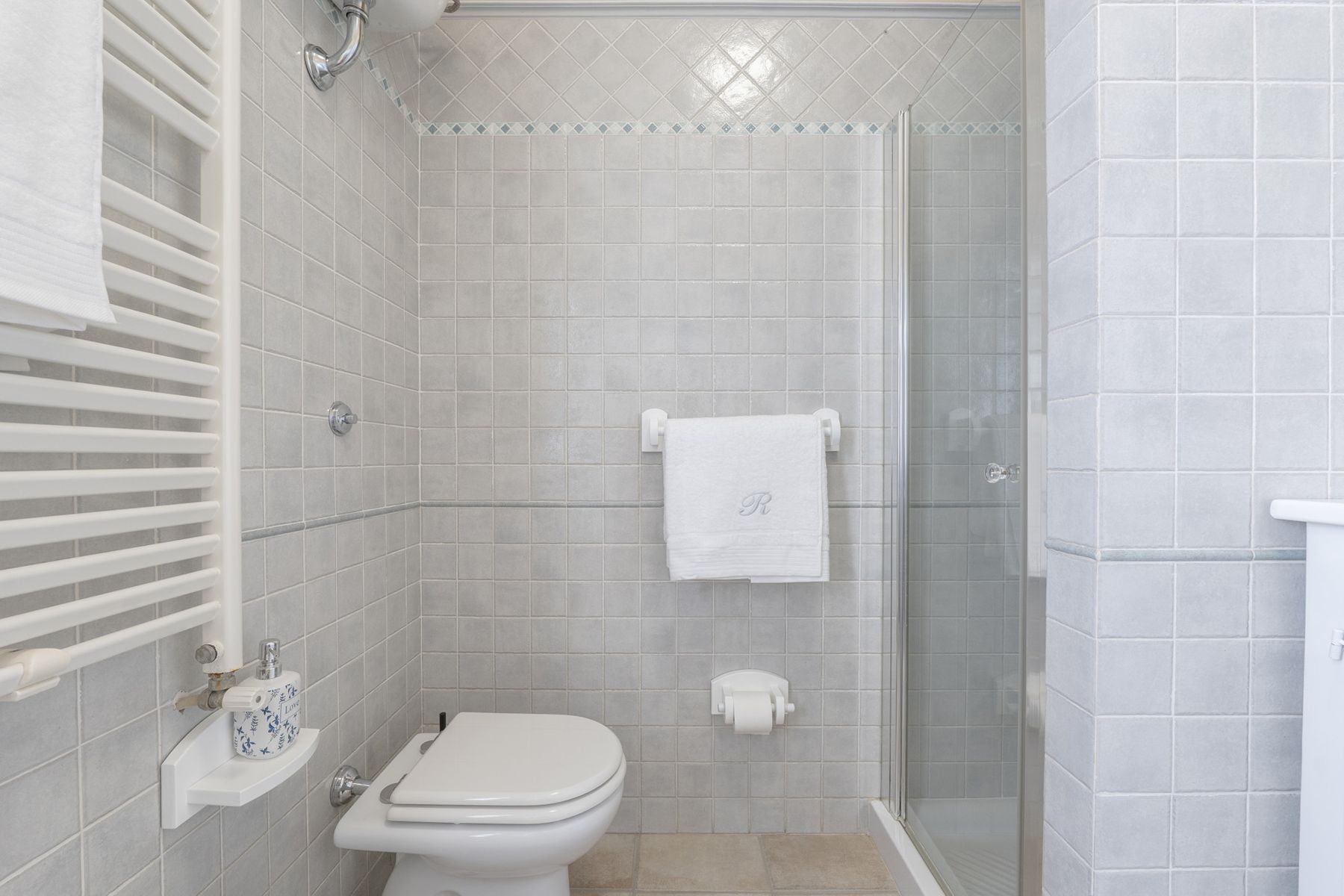 Bagno con piastrelle grigie e doccia