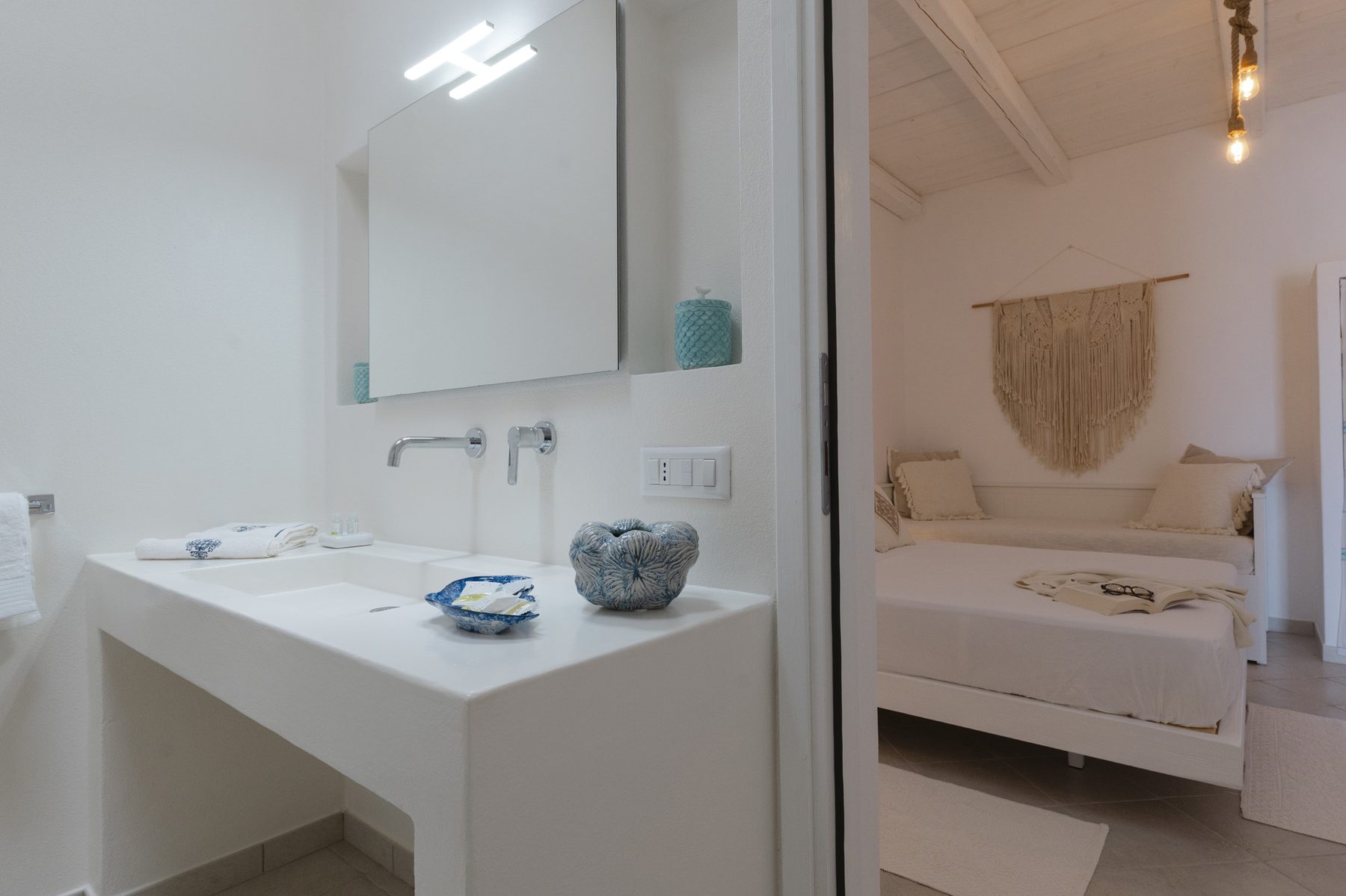 Bagno con lavabo bianco e vista sulla camera
