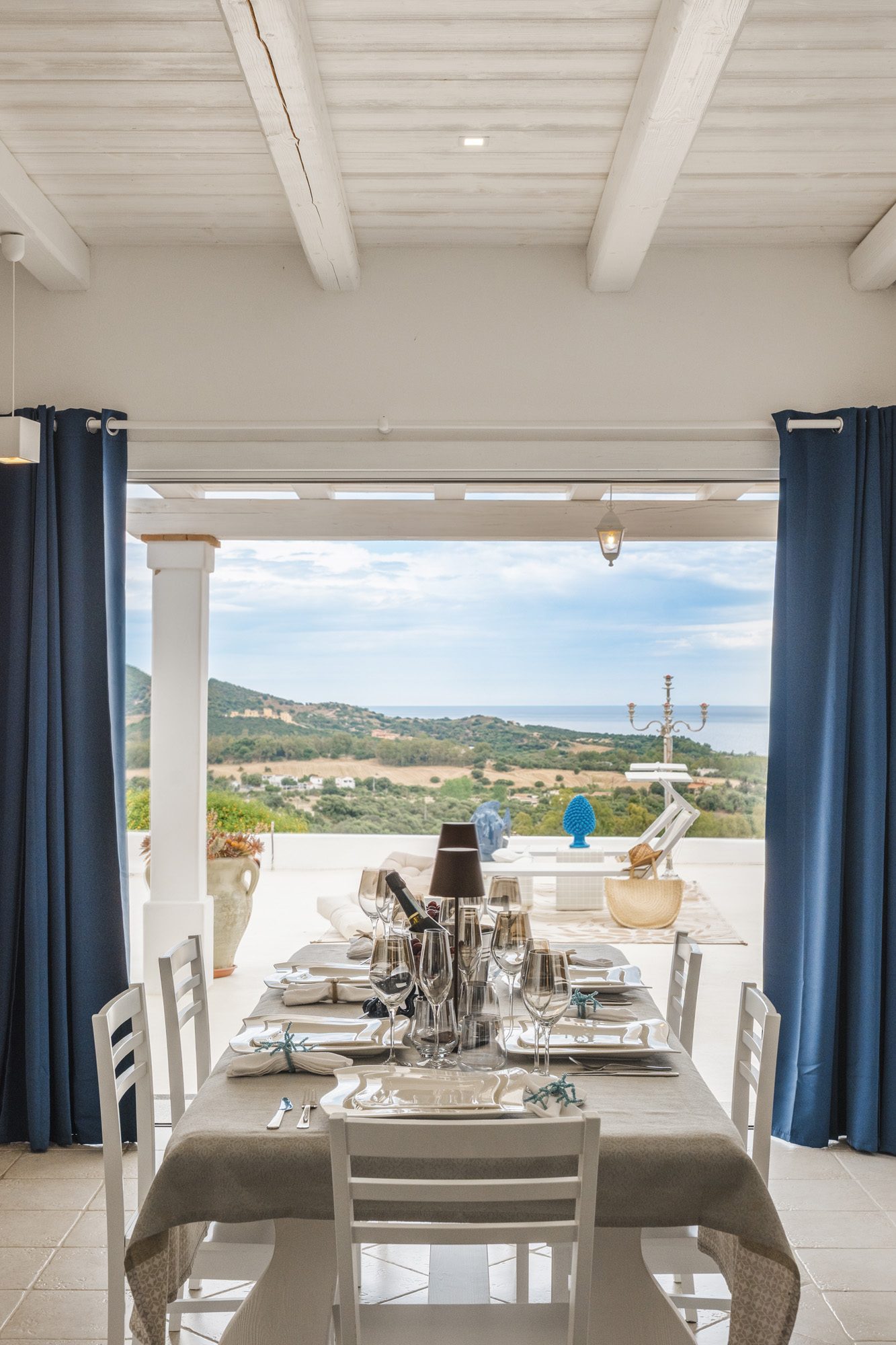 Sala da pranzo con vista mare e tende blu