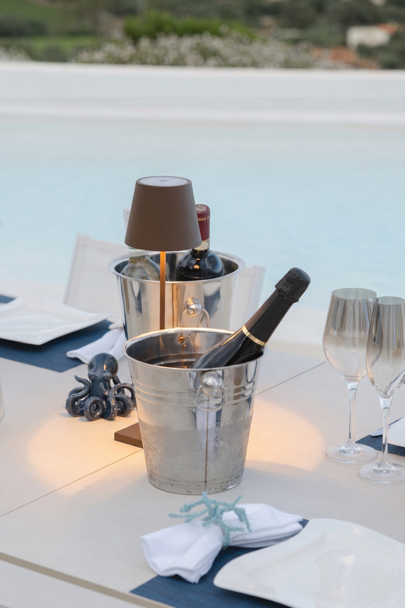 Bollicine e vino in fresco nei secchielli a bordo piscina